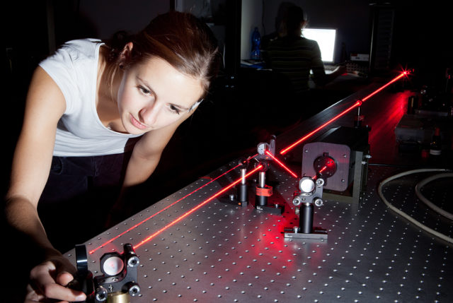 Studentin kalibriert Laser-Versuch